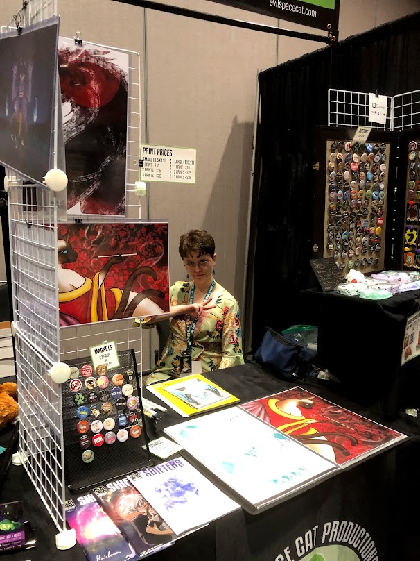 Hi to those reviewing this page, I'm ShadowsMyst, and I've been vending for many years. I have vended at Vancoufur, Rainfurrest, Furlandia, as well as non furry events like San Diego Comic Con, Anime Evolution, Cos & Effect, and Northwest Fanfest. I am revamping my vending setup for this year, this is a bit of an old picture, but its the only one I've got at the moment.<br><br>My products are primarly<br>* art prints<br>* buttons,<br>* magnets<br>* keychains,<br>* stickers<br>* comics<br>* commissions including badges, traditional at con and take home digital.<br>I'm also adding plush fursuit props, vinyl stickers, and other fursuit related items, like tails, to my line up.
